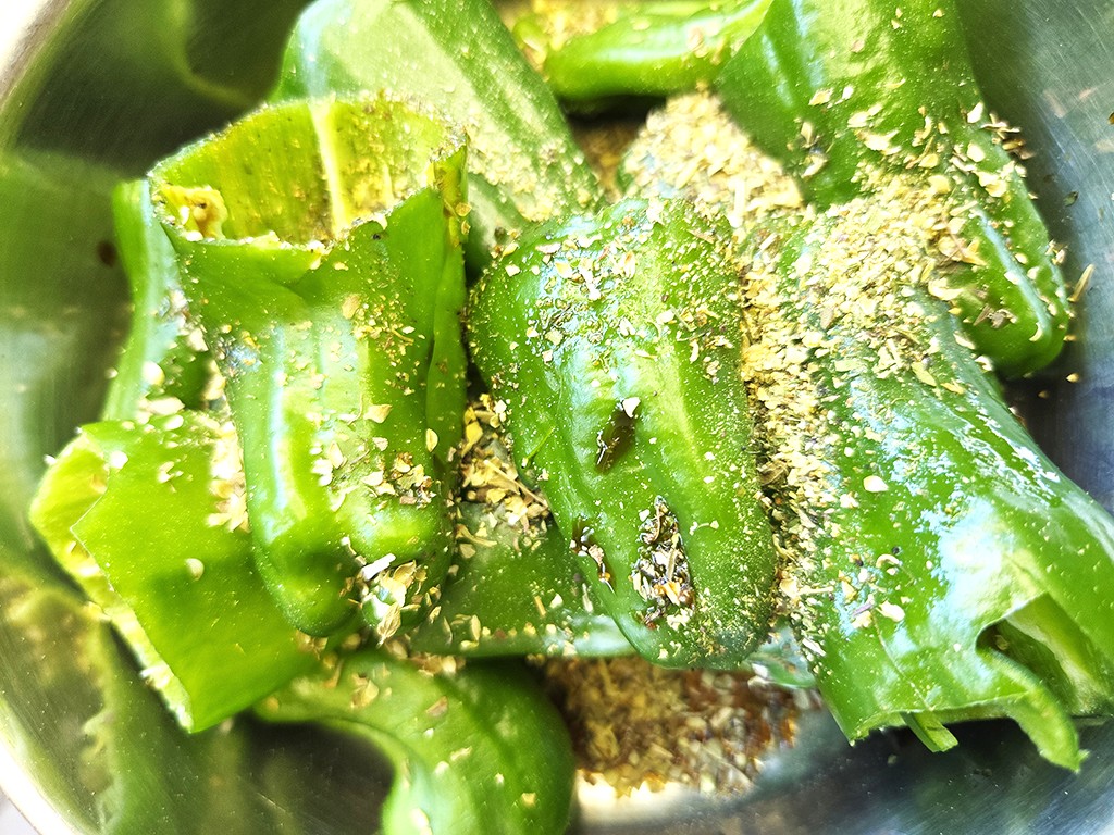 Wheaty | Bio BBQ Green Piece Seitan | Herzschatz Green bell pepper pieces sprinkled with breadcrumbs in a metal bowl, ready for cooking.