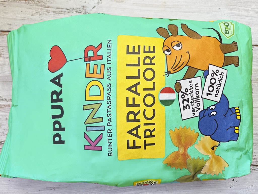 Bright green bag of farfalle tricolore pasta with playful cartoon animals and an Italian flag-themed label.