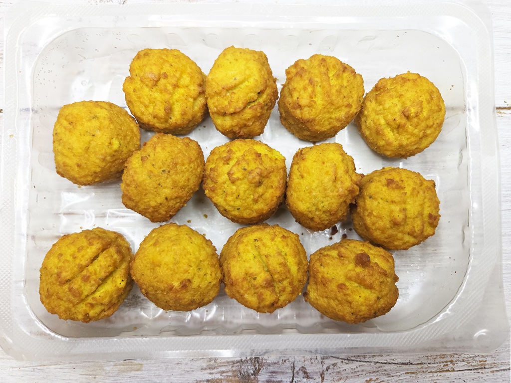 SOTO | Falafel Traditionell | Herzschatz Fifteen golden falafel balls arranged on a clear plastic tray, ready to serve.