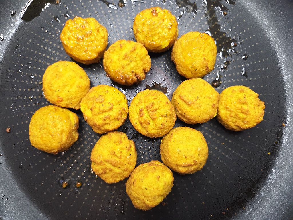 SOTO | Falafel Traditionell | Herzschatz Golden orange fried croquettes arranged in a black skillet, ready to serve