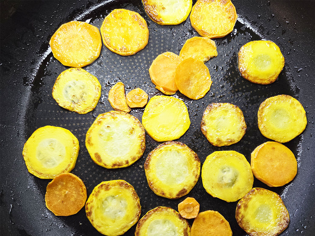 Tofoo & Co | Smoked Tofu | Herzschatz Golden fried potato coins sizzling in a black nonstick skillet with crispy edges**?**