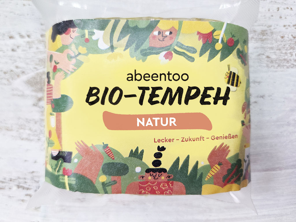Front of abeentoo BIO-TEMPEH Natur packaging with colorful garden illustration and the words 'abeentoo BIO-TEMPEH NATUR'