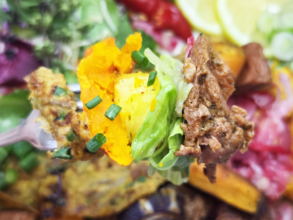 Planted. | Filet-Würfel a la mexicana | Herzschatz Close-up of a forkful with orange squash, greens, and shredded meat in a colorful dish