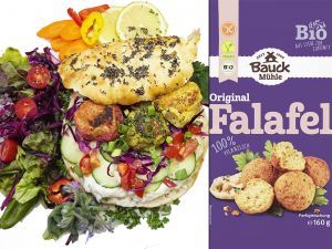 Falafel wrap packed with vegetables and greens, beside a Bauck M&uuml;hle Original Falafel mix box.