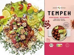 Colorful plate of rice with cubed tempeh, peppers, herbs, lime wedges, and greens beside a pink TEMPEH packaging box labeled Kidney Bean Mexican.