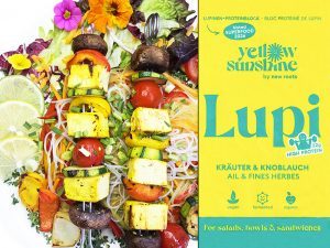 Left: colorful vegetable noodle dish with skewers, lime wedges, and edible flowers; right: bright yellow Lupin high-protein packaging labeled 'Lupi'